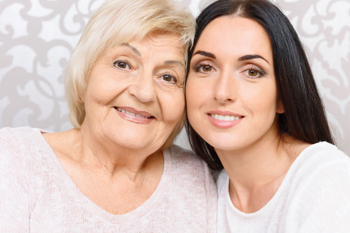 older and younger woman with white background