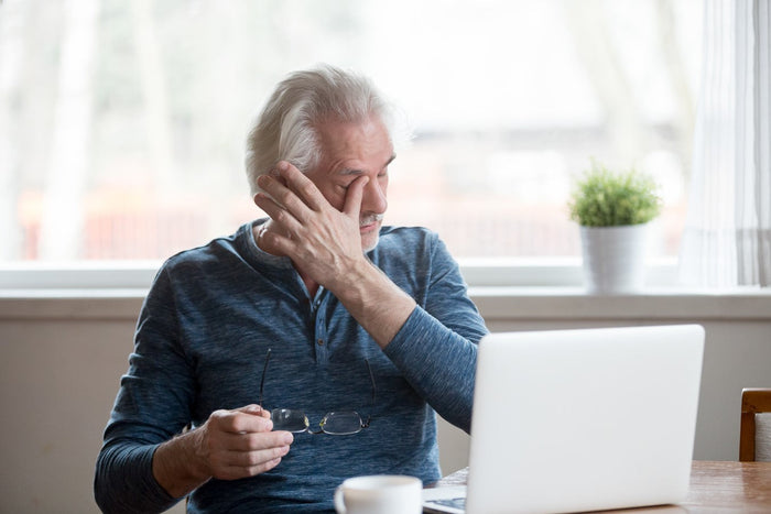 man rubbing his eyes