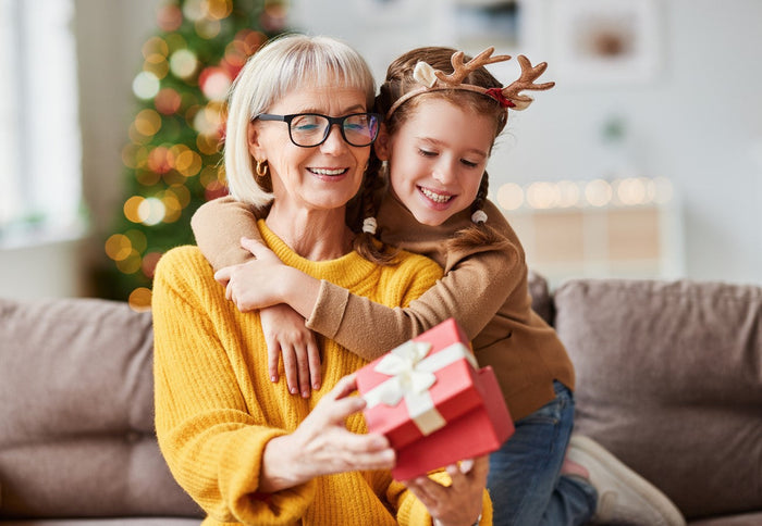 smiling grandmother and grand child opening gifts