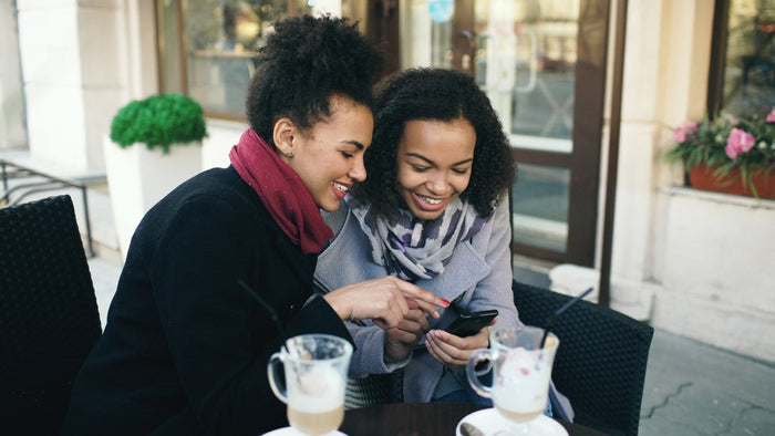 women smiling looking at phone