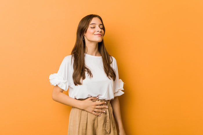 women holding hand over stomach