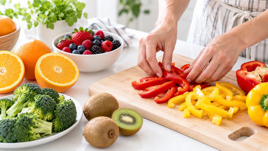 Fresh vitamin C rich foods including oranges, kiwi, bell peppers and broccoli on a bright kitchen counter
