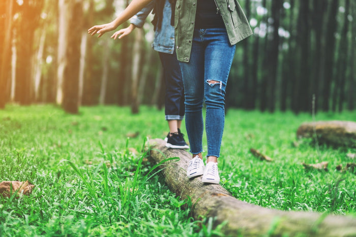 two people balancing on log